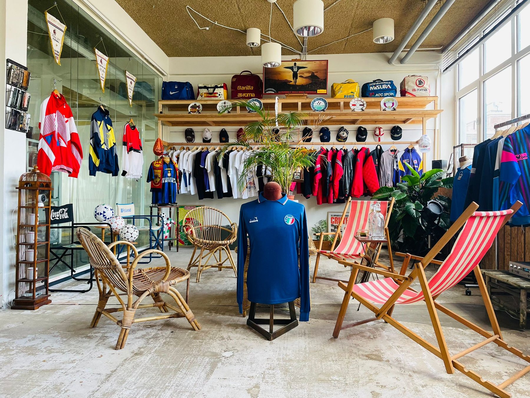 Small retro television and plant in front of vintage football shirts